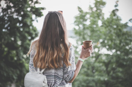 Woman holding brown paper cup