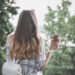 Woman holding brown paper cup